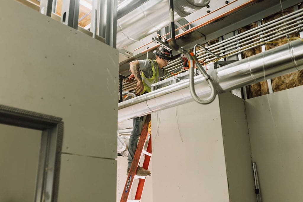 Precise contractor inspecting HVAC system